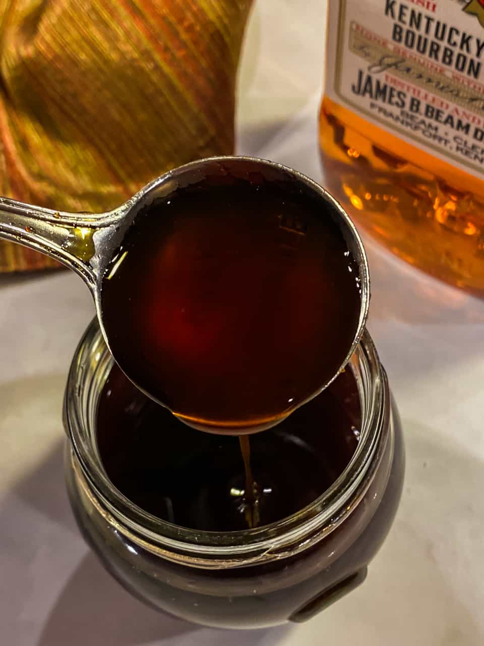 Top shot of bourbon glaze in a glass jar with a spoon