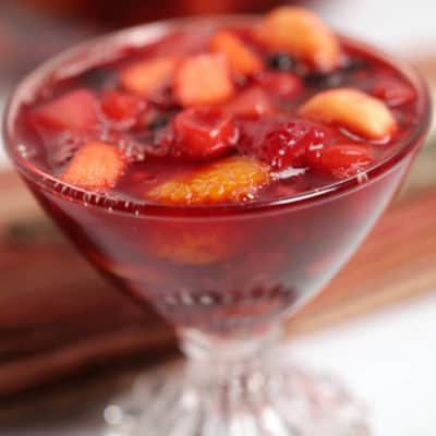 Cherry Jello Salad with fruit in a clear parfait glass