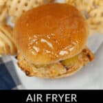 Close-up of an air-fried Copycat Chick Fil A Sandwich with pickles on a brioche bun, surrounded by waffle fries. Text at the bottom reads: "Air Fryer Copycat Chick Fil A Sandwich.