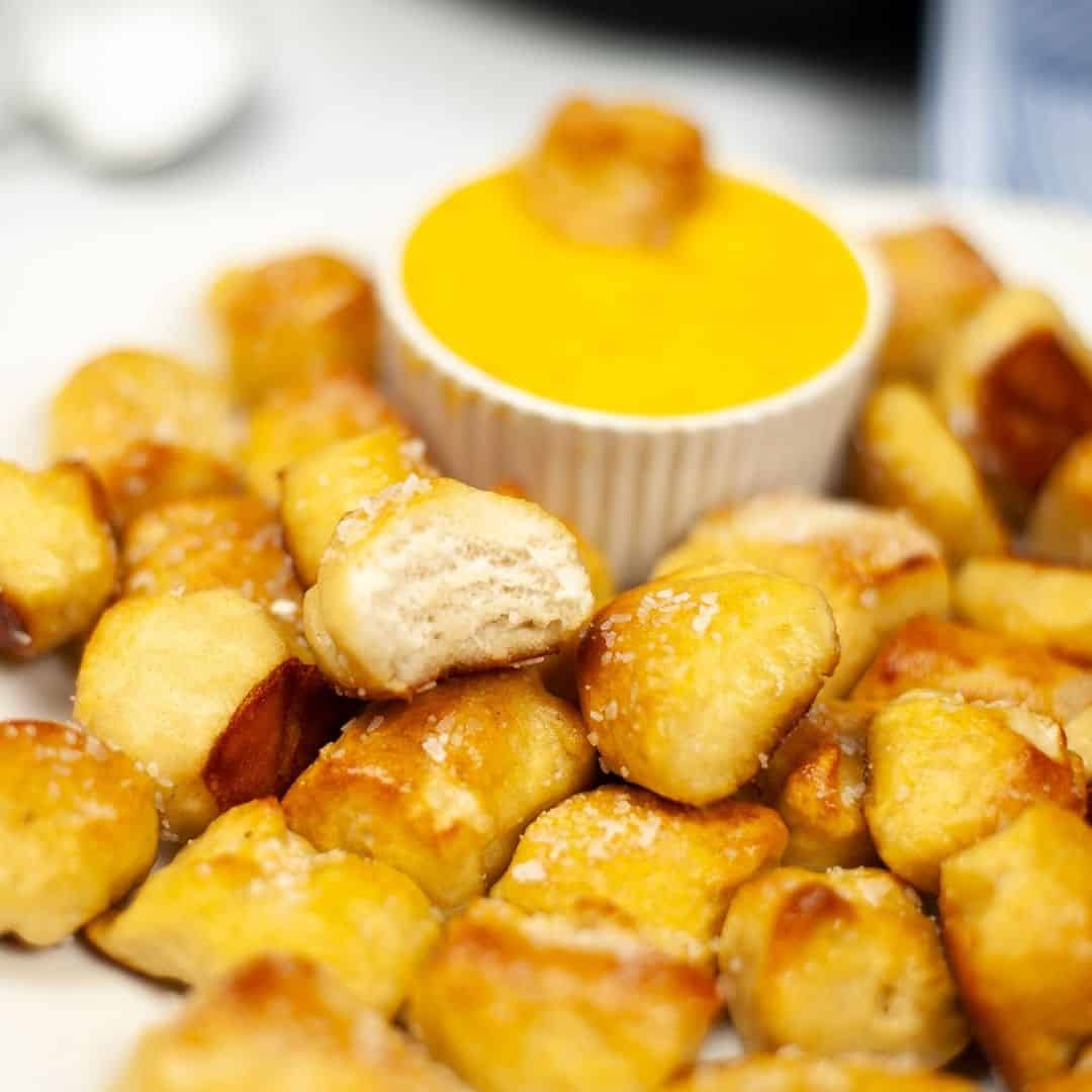 Side shot of air fryer pretzel bites in cheese