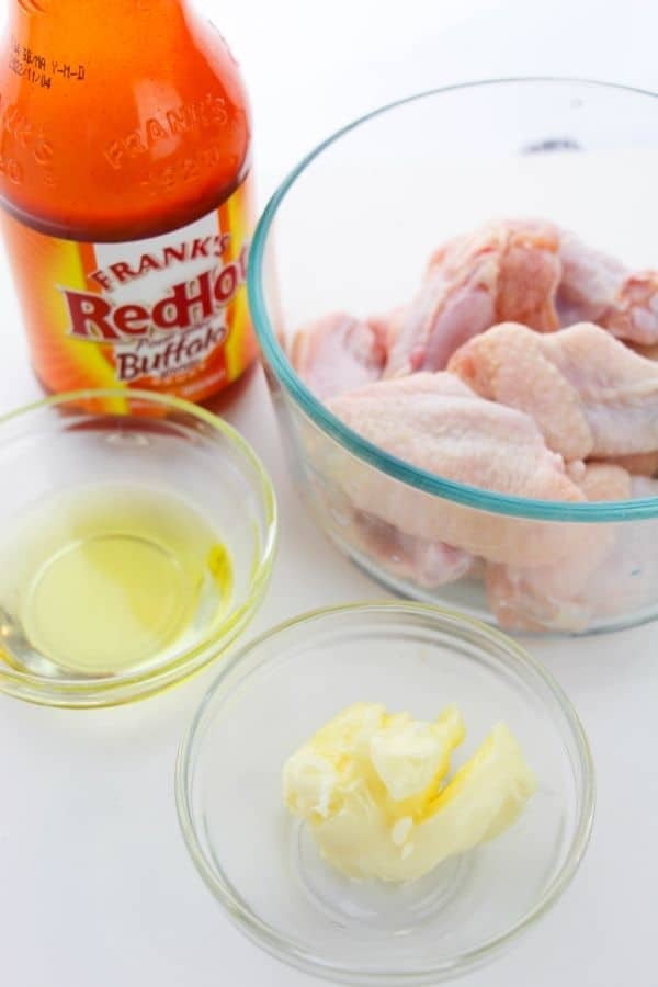 Glass bowls with raw wings, butter hot sauce etc.