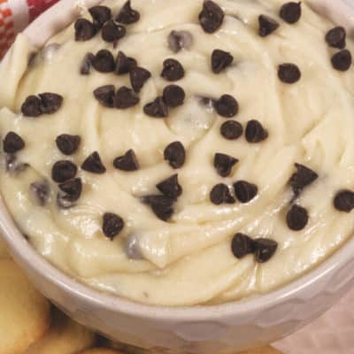 Bowl of cookie dough dip with side of vanilla wafers and a red stripe napkin