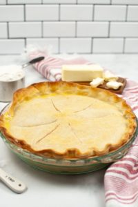 Crisco Pie Crust ina glass pie dish with ingredients and a red and white stripped napkin