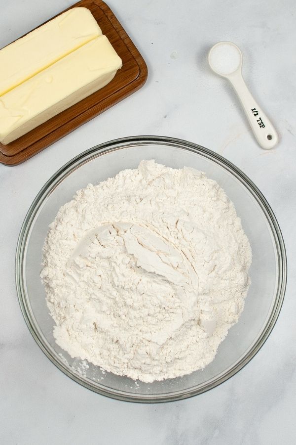 Crisco Pie Crust Ingredients, glass bowl with flour, butter, and measuring spoon.