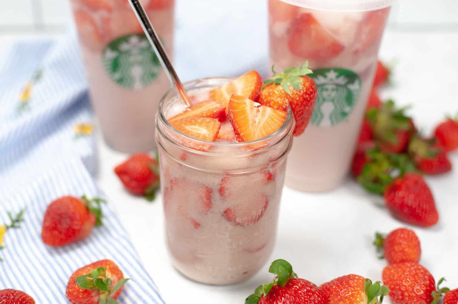Far shot of pink drinks surrounded by strawberries