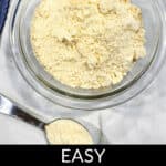 A bowl of homemade Bisquick mix rests on a kitchen counter, with a measuring spoon beside it, labeled "Easy Homemade Bisquick.