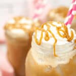 Close-up of three mason jars filled with coffee caramel drizzle, each with a pink-striped straw.