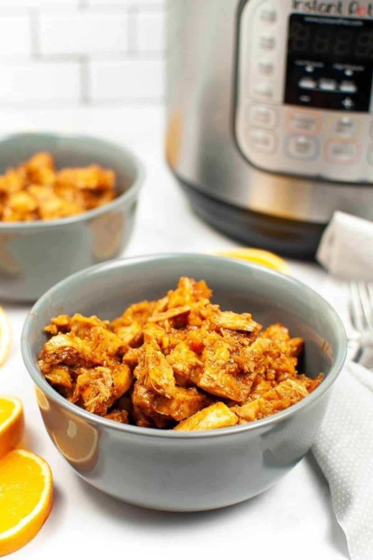 A bowl of the meal with the pressure cooker in the background.