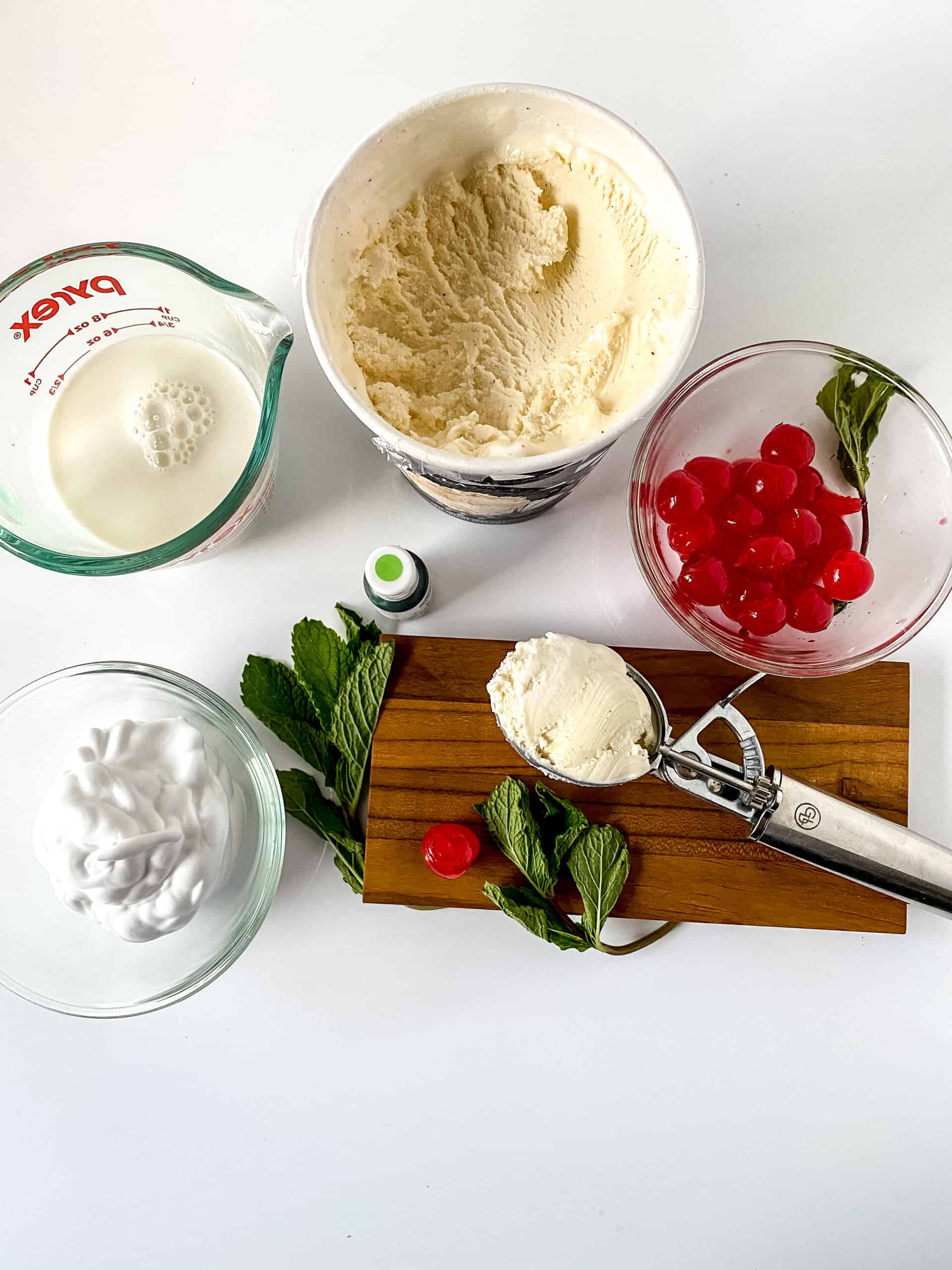 Ingredients for a Shamrock Shake Recipe displayed on a wooden cutting board.