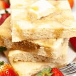 A stack of the sheetpan pancakes surrounded by berries.