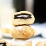 Air Fried oreos stacked on a plate with a cut open one on top revealing the oreo.