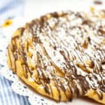 A homemade funnel cake made in the instant pot on a white plate.