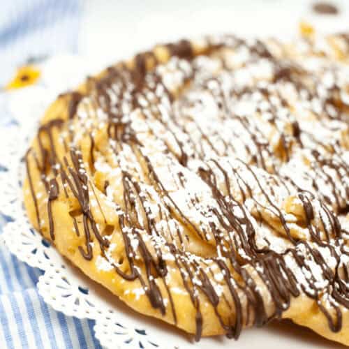 A homemade funnel cake made in the instant pot on a white plate.