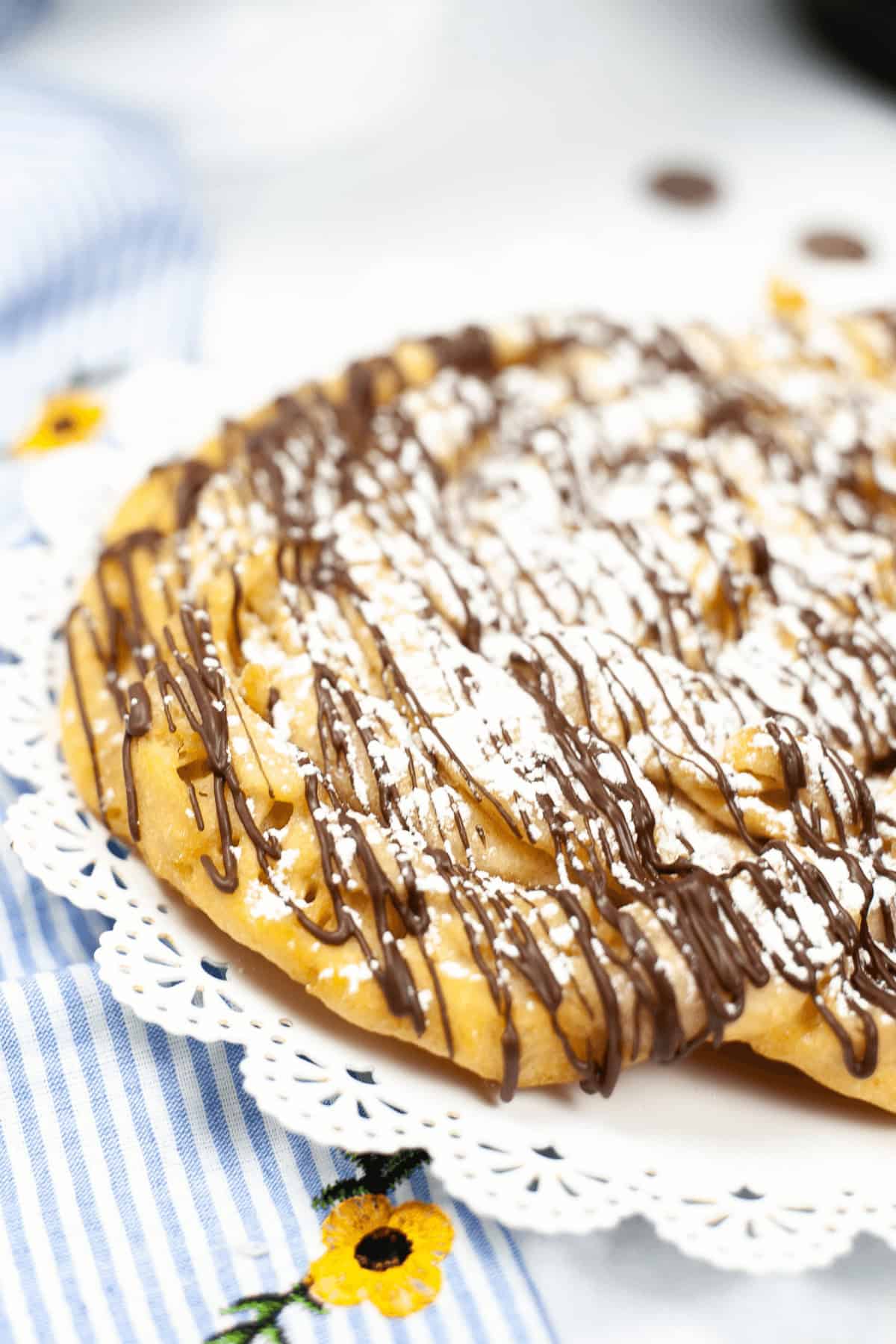 A homemade funnel cake made in the instant pot on a white plate.