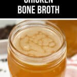 A jar of Instant Pot Chicken Bone Broth sits on the table, surrounded by a towel and fresh herbs, with a label at the top proudly displaying its name.