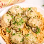 Plate of Veal Piccata meatballs on top of spaghetti.