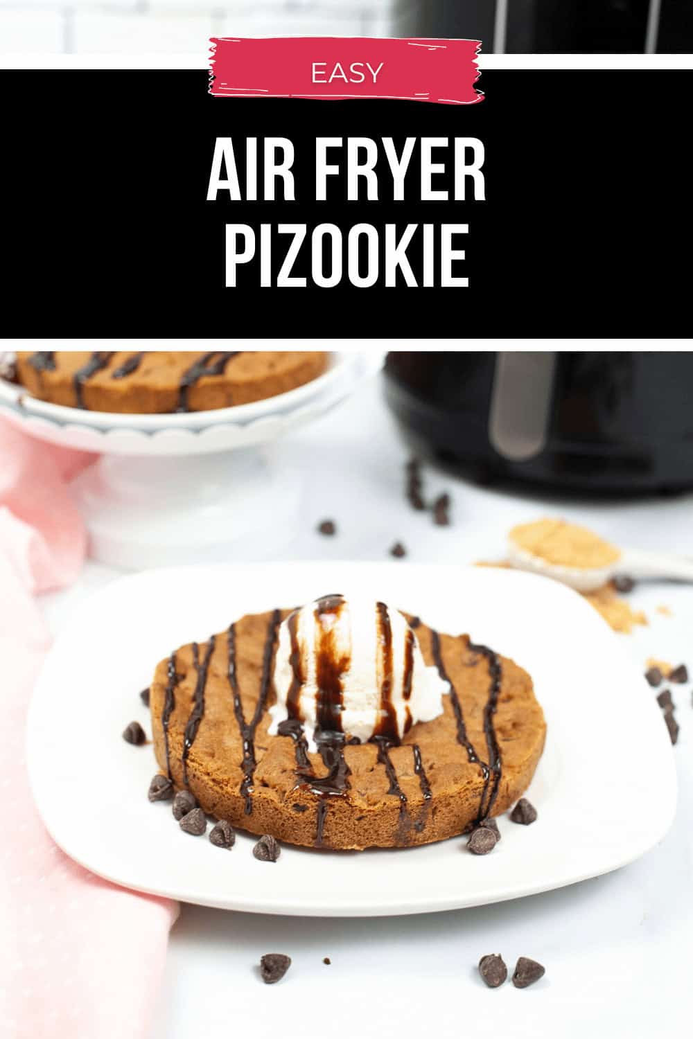 A scrumptious chocolate chip cookie topped with creamy vanilla ice cream and rich chocolate drizzle, served on a white plate and cleverly labeled "Easy Air Fryer Pizookie," makes for a delightful treat.