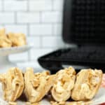 A closeup of a plate of banana tacos next to a waffle iron.