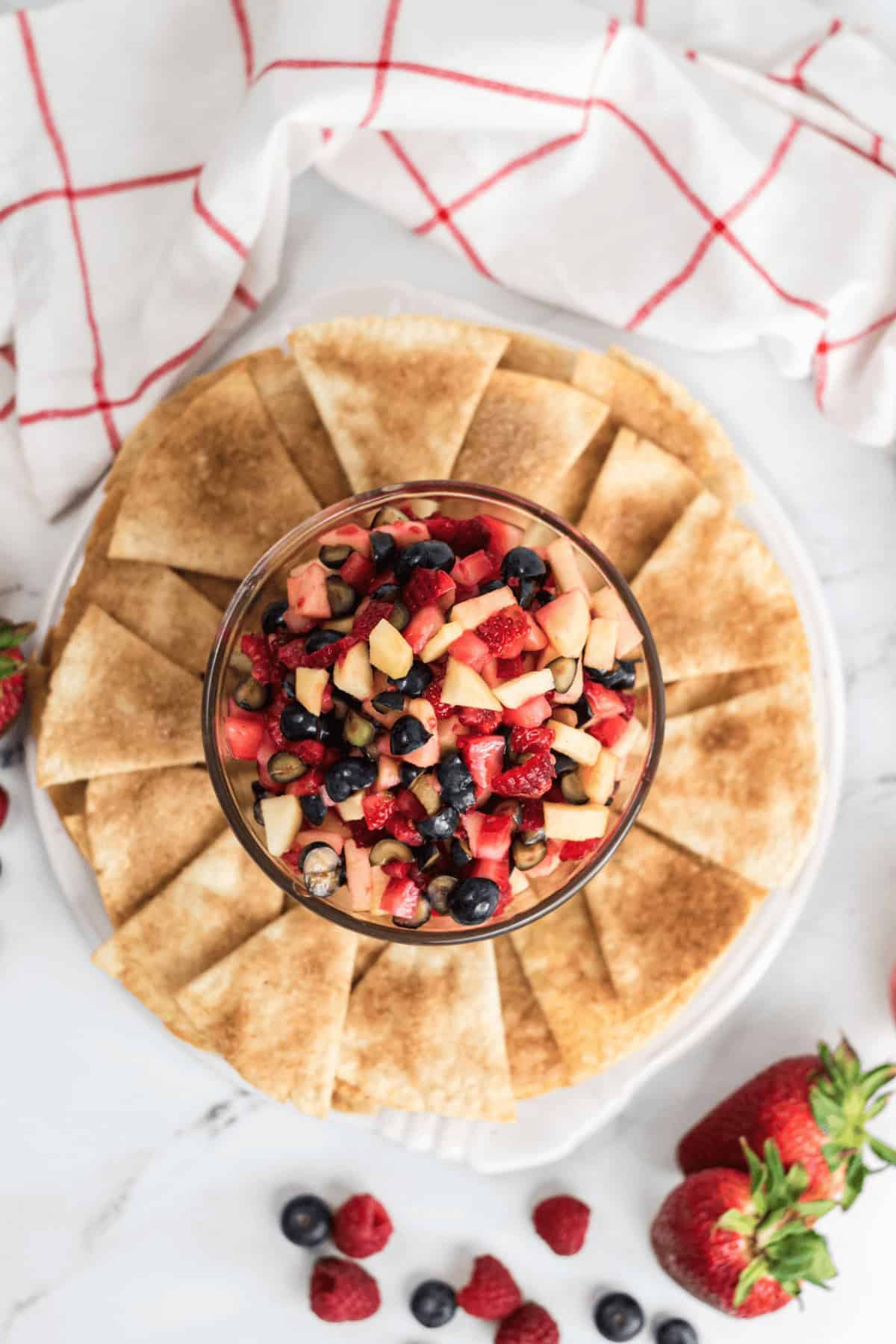 A glass bowl of vibrant appetizer with crispy cinnamon sugar tortilla chips.