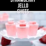 A display of pink strawberry jello shots on a white cake stand, topped with red candies, with a pink "Starburst" label at the top.