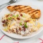 Dish of loaded potato salad with chicken and a fork.
