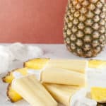 Pineapple on counter with pina colada pops and sliced pineapple.