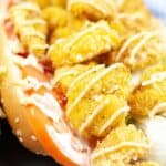 A classic meal, packed with fried shrimp, crisp lettuce, and juicy tomato, all drizzled with a tangy yellow sauce and served in a fresh hoagie roll.