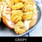 Plate with a crispy shrimp po' boy sandwich, perfectly air-fried and garnished with sauce and fresh vegetables. Text overlay reads: "Crispy Air Fryer Shrimp Po Boy Sandwich.