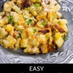 A serving of cheesy breakfast potatoes with bacon and herbs on a gray plate. Text reads: "Easy Cast Iron Skillet Breakfast Potatoes and Cheese—perfect for your next cast iron skillet breakfast.