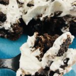 Fork full of Oreo dump cake on a plate with a slice of the cake.