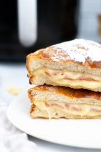 Side view of a stacked monte cristo sandwich on a plate.