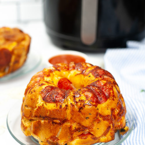 Clear dish of Pizza bread with an air fryer in the background.