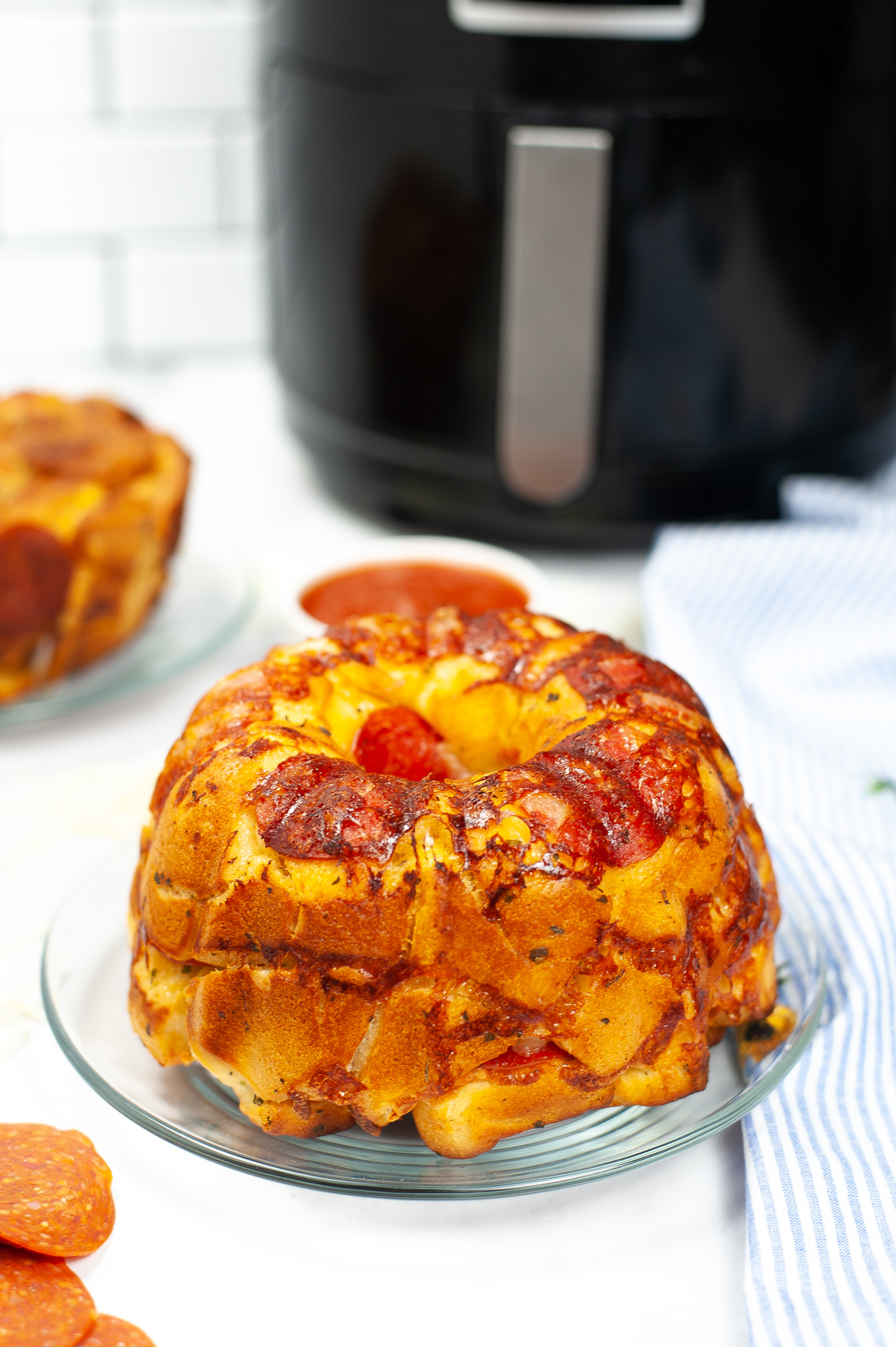Clear dish of Pizza bread with an air fryer in the background.