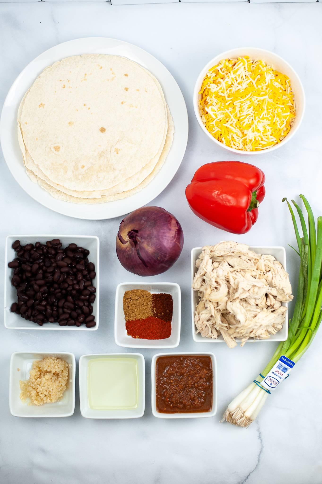 Tortillas, vegetables, black beans and seasonings for Shredded Chicken Quesadilla Melt.