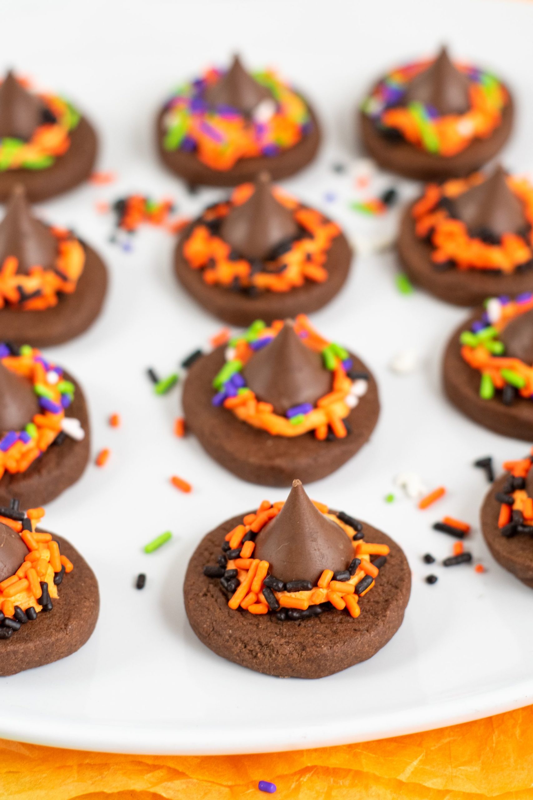 Closeup on a tray of the witch hat cookies on a white platter.
