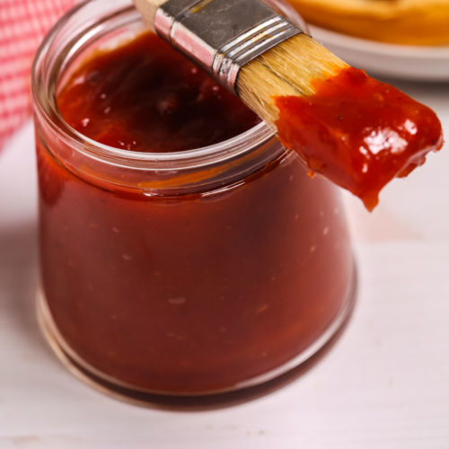Jar of Chipotle Barbecue Sauce with a basting brush on top.