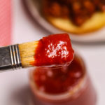 Close up of a brush scooping out the Chipotle Barbecue Sauce.