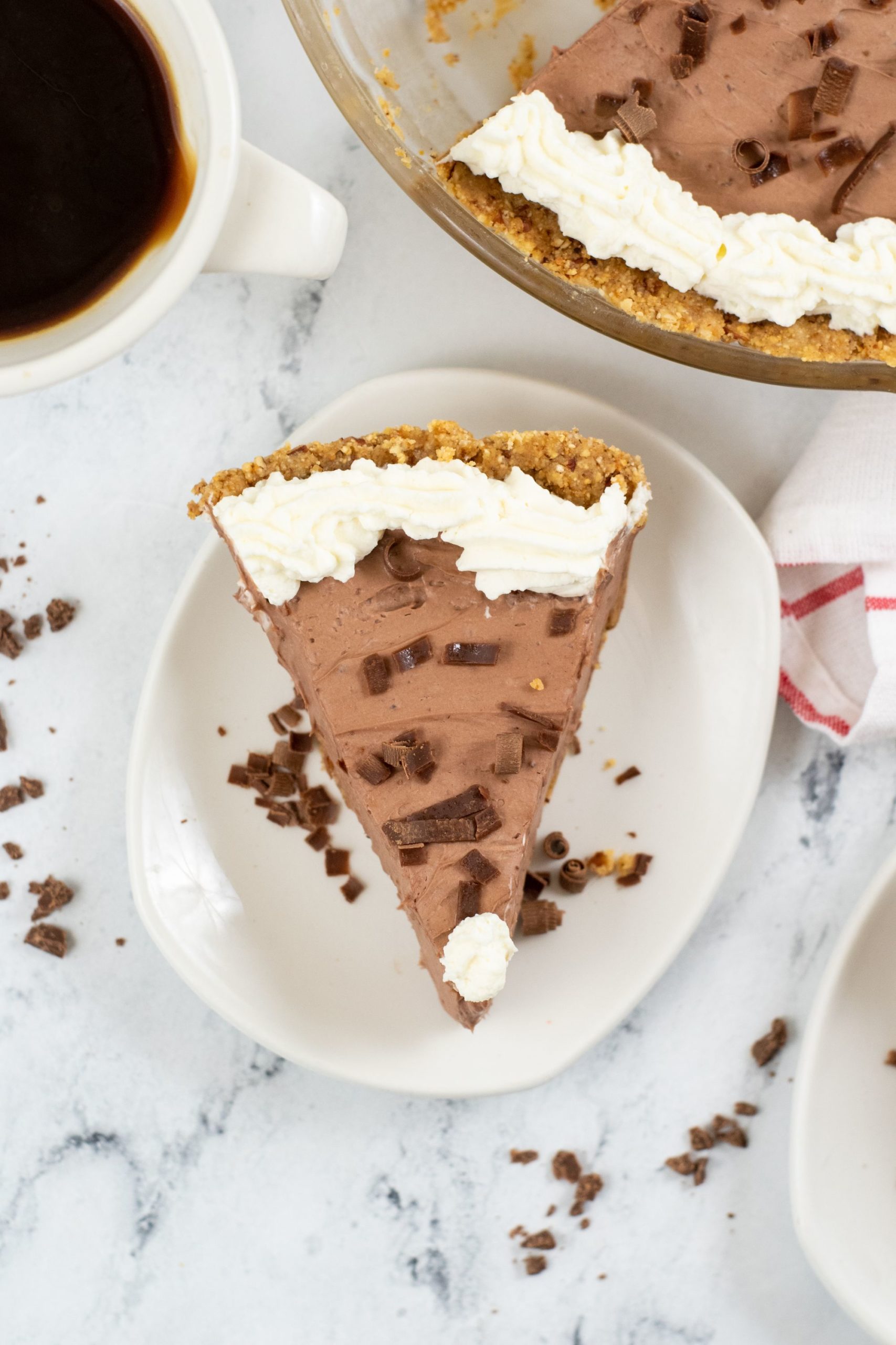 Chocolate Jello Pudding Pie with a cup of coffee and pie dish in the background.