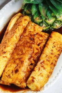 Tangy grilled pineapple on a white dish.