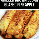 A dish of brown sugar-glazed pineapple slices, perfectly grilled and caramelized to a golden brown color, served on a white plate. The text reads "Brazilian Grilled Brown Sugar Glazed Pineapple.
