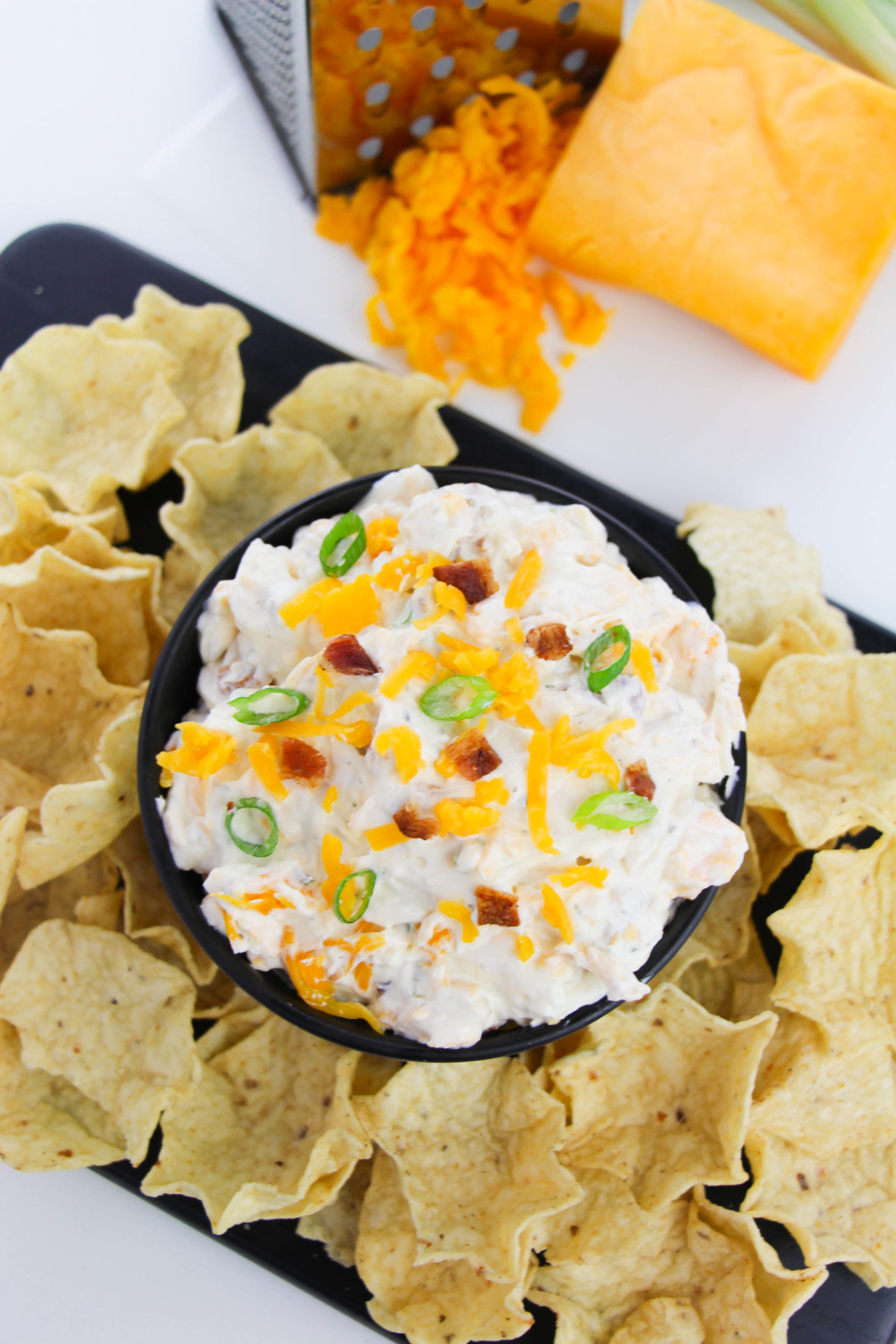 Bacon Ranch Dip surrounded by dips and cheese on the side.