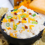 Bacon Ranch Dip pictured from the side top of this dish surrounded by chips.