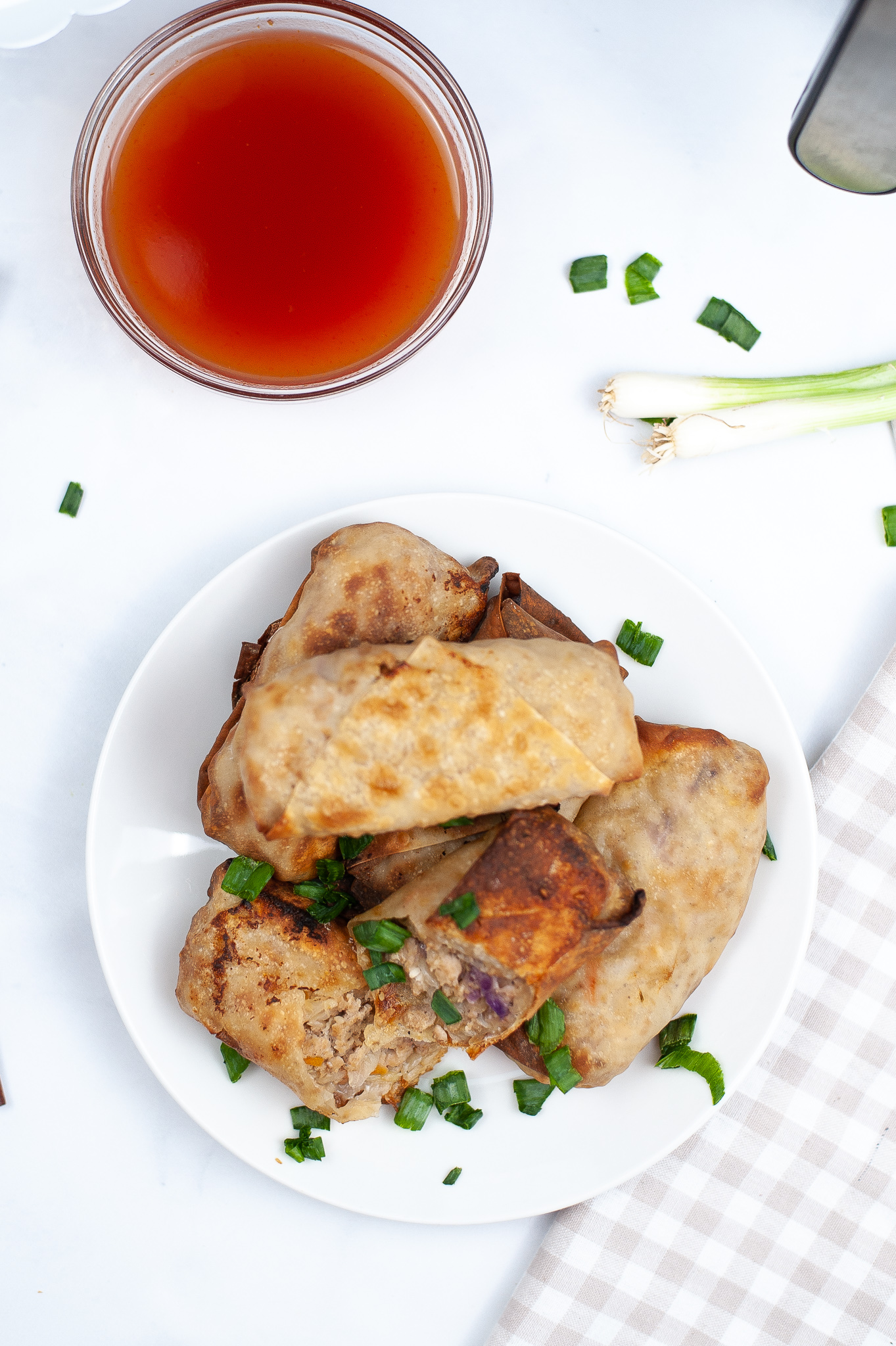 Air Fryer Chicken Egg Rolls pictured from the top stacked on a white plarte.