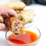 Piece of Air Fryer Chicken Egg Roll dipped into sauce.