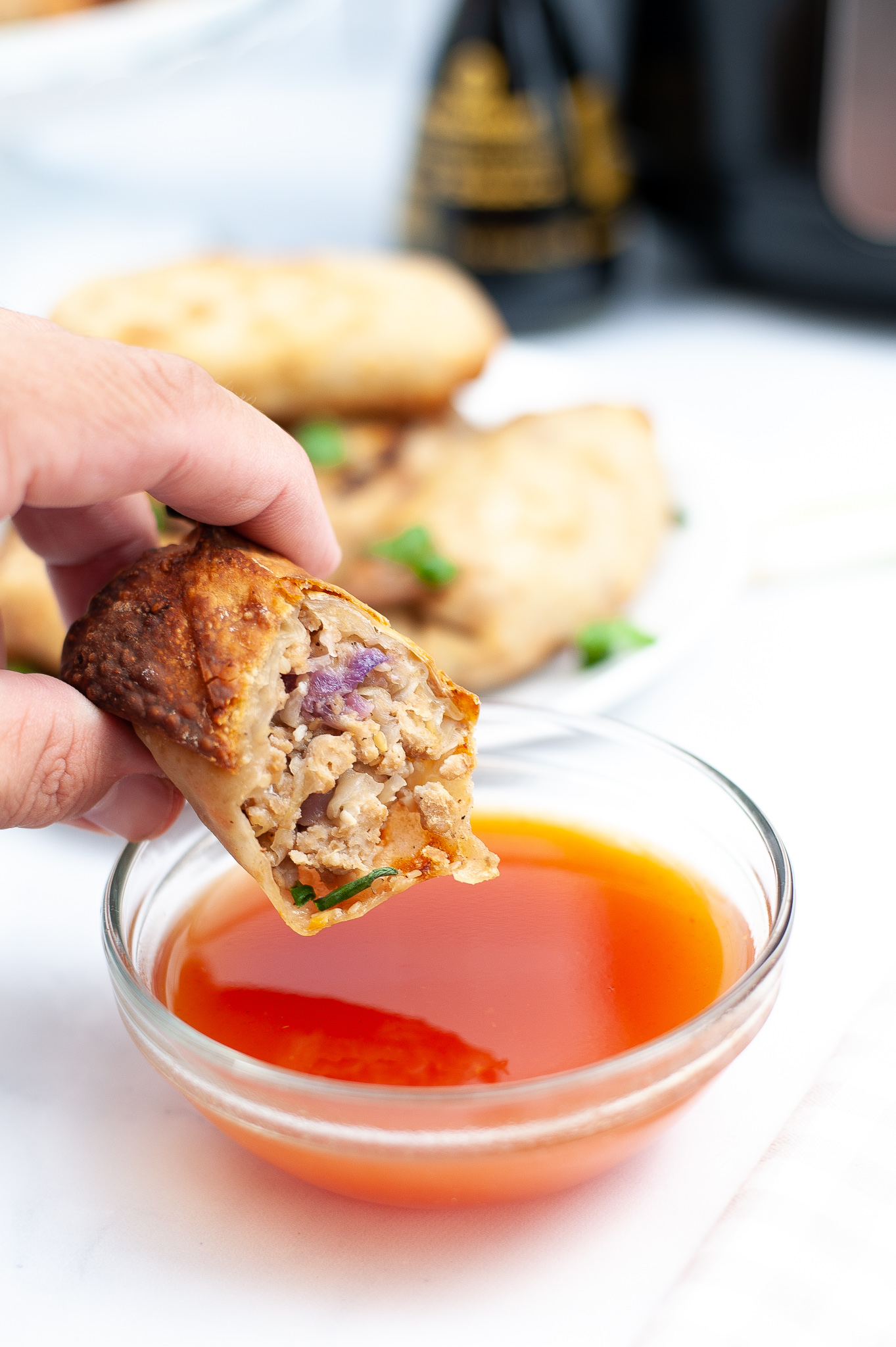 Piece of Air Fryer Chicken Egg Roll dipped into sauce.
