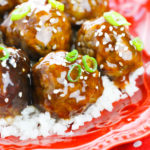Honey Garlic Meatballs over rice on a red scalloped plate with a red and white dot tablecloth.