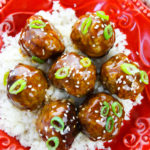 Top shot of Honey Garlic Meatballs over rice with scallions on top.