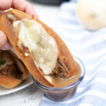 Instant Pot French Dip Sandwich being held by a hand in close up.