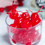 A clear glass dish of cherries.