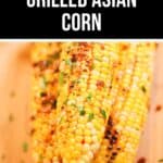 Three grilled Asian Corn cobs topped with herbs and spices are arranged on a wooden surface. The text above reads "Flavorful Grilled Asian Corn.